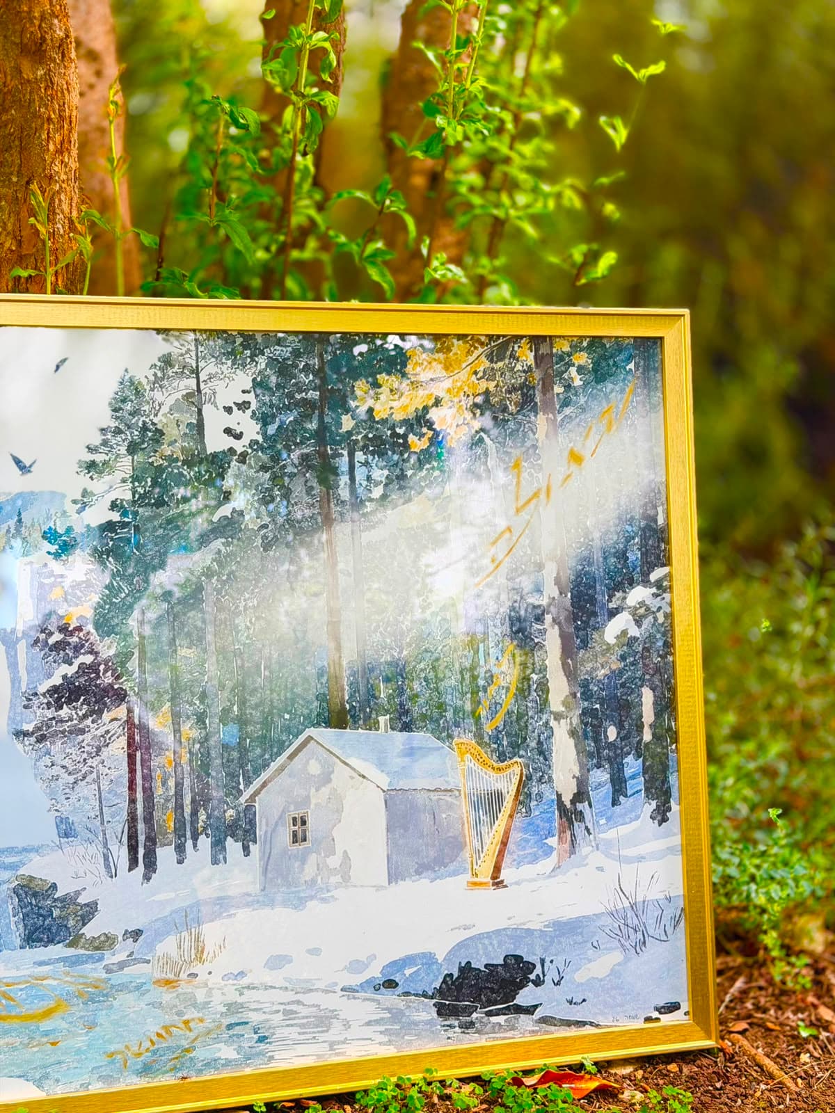 Shamil framed artwork leaning against a tree in the forest