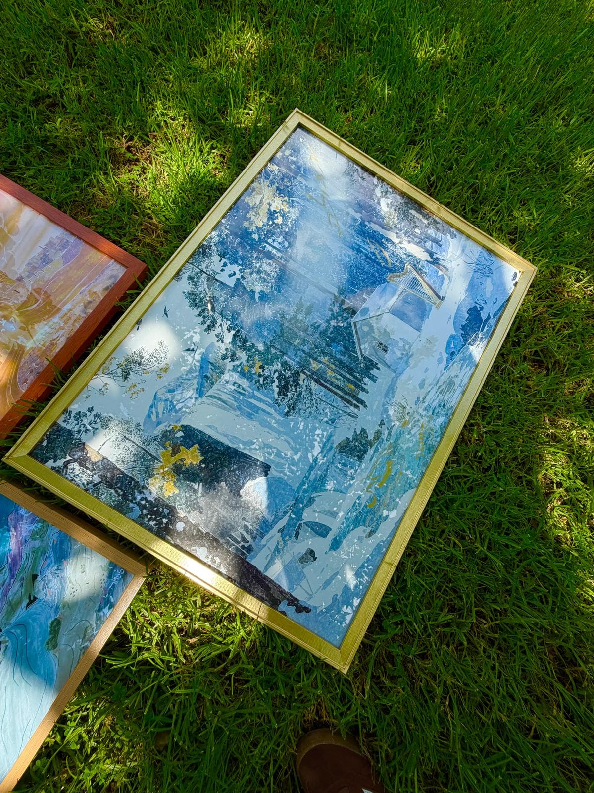 Shamil framed artwork on grass beside another piece from the series