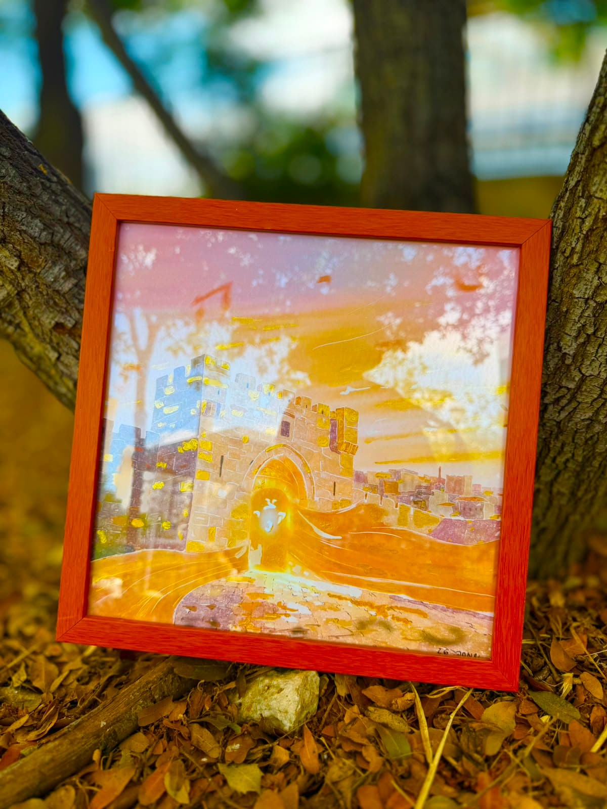Ufaratza framed artwork resting against an olive tree