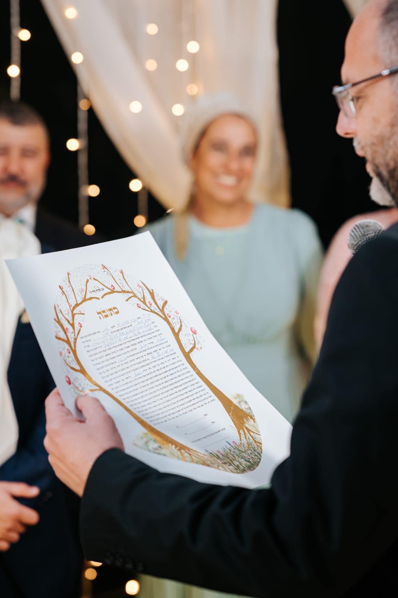 Couple with their ketubah on their wedding day